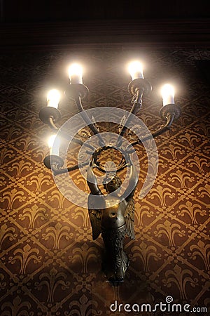 Bronze angel wall-mounted lamp with five lights on the wall with vintage brown wallpaper Stock Photo