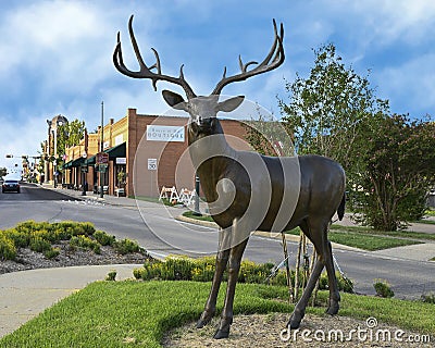 Bronze buck standing alertly, part of `A Wilderness Welcome` by Archie Saint Clair in the historic district of Grapevine Editorial Stock Photo