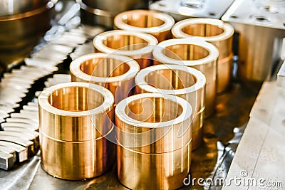 Bronze bushings for plunger hydraulic pumps, made on a cnc lathe, stand on a rack in a warehouse Stock Photo