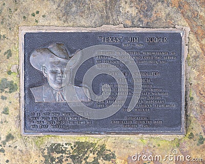 A bronze memorial plaque attached to a rock in front of the gazebo on the east side of the historic town square. Editorial Stock Photo