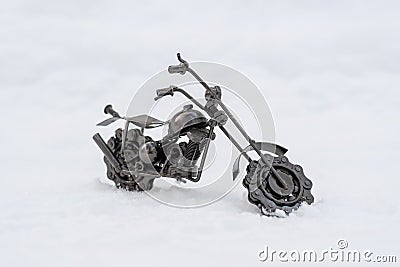 Bronze metal toy model of a road motorcycle stands on a snowy road, white background Stock Photo