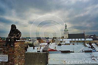 Bronze sculpture of the Chimney sweep on the roof of a house in Lviv Editorial Stock Photo