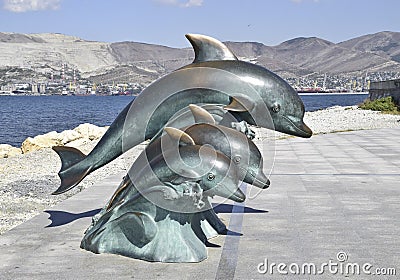 The bronze sculpture of three dolphins on the beach Editorial Stock Photo