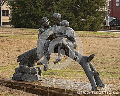 A bronze sculpture titled `Children Reading` by unknown artist located in the Dr. Glenn Mitchell Memorial Park in McKinney, Texas. Editorial Stock Photo