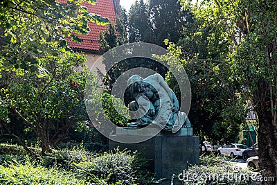 Bronze Statue Amidst Lush Greenery in a Prague Garden Editorial Stock Photo