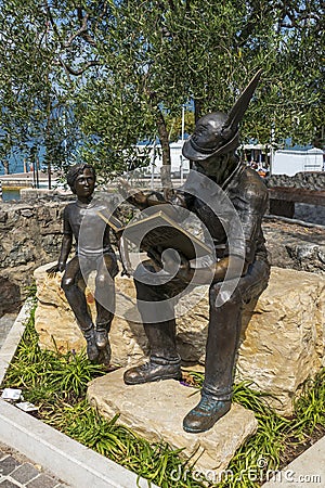 Bronze statue, soldier reading boy from book, in Torri del Benaco Editorial Stock Photo