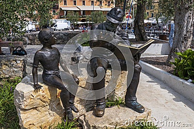 Bronze statue, soldier reading boy from book, in Torri del Benaco Editorial Stock Photo