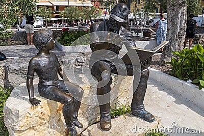 Bronze statue, soldier reading boy from book, in Torri del Benaco Editorial Stock Photo