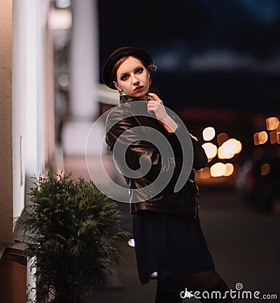 Brooding young woman looking at the lights in the night city. Stock Photo