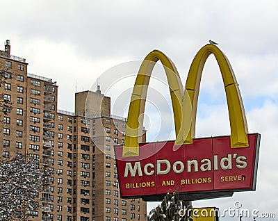 McDonald's fast food restaurant sign with golden arches in front of a tall high rise building in Brooklyn, New York City. Editorial Stock Photo