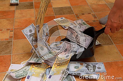 Broom sweep money in the scoop. Stock Photo