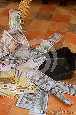 Broom sweep money in the scoop. Stock Photo