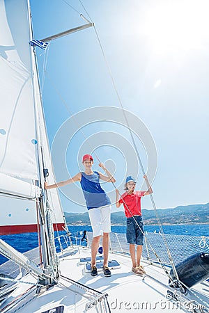 Brother and sister on board of sailing yacht on summer cruise. Travel adventure, yachting with child on family vacation. Stock Photo