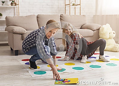 Brother And Sister Having Fun Playing Twister Game On Floor Stock Photo