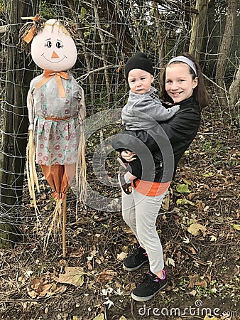 Brother and sister with scarecrow Stock Photo