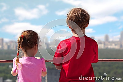 Brother, sister stand of roof of high building Stock Photo