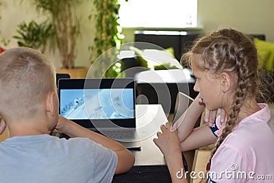 Brother and sister teens watching a movie on a computer at home Stock Photo