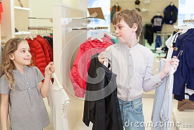 Brother with sister trying on clothes in store Stock Photo