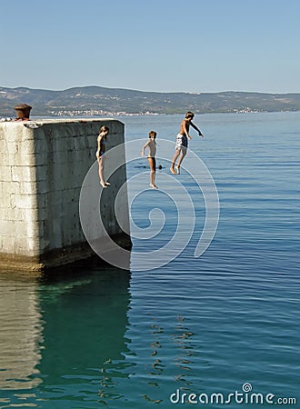 Brother and sisters jumping in water Stock Photo