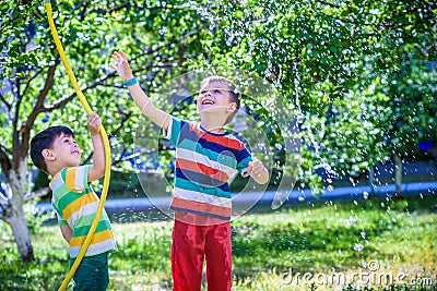 Brothers having fun splash each other with water in the village Stock Photo