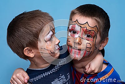 The brothers hug and look at the camera. Childrens with face painting Stock Photo