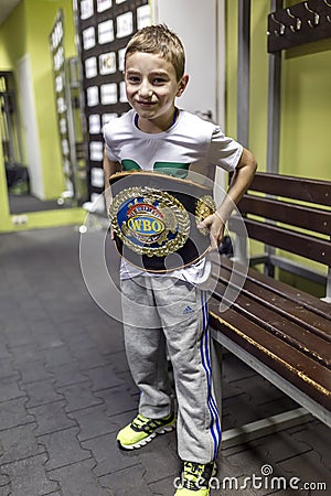 Brovary. Ukraine, 14.11.2015 a smiling little boy is trying on a champion boxing belt Editorial Stock Photo