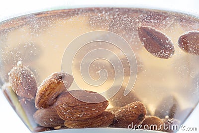 Almond kernels soaked in water close-up, delicious macro Stock Photo