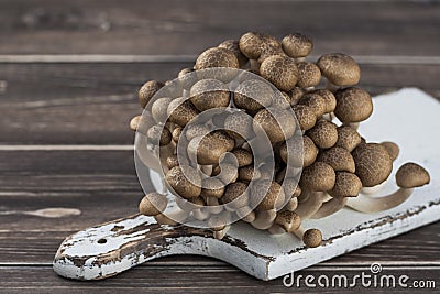 brown beech mushroom on white desk and wood table. Stock Photo