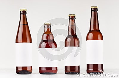 Brown beer bottles collection different type with blank white label on white wooden board, mock up. Stock Photo