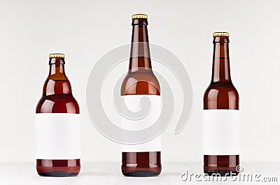 Brown beer bottles collection different type with blank white label on white wooden board, mock up. Stock Photo