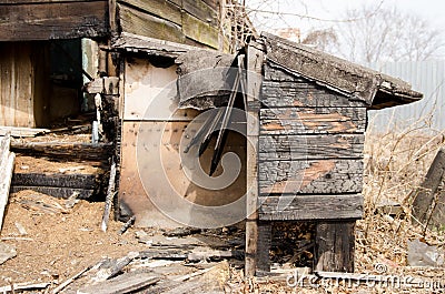 Brown and black burnt house of wooden planks with embossed texture without door and broken wall. damage to the building from fire Stock Photo