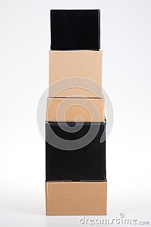 Brown black cardboard boxes stacked on each other pyramid on white grey background Stock Photo