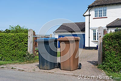 Brown and blue wheelie bins outside a house. UK Editorial Stock Photo