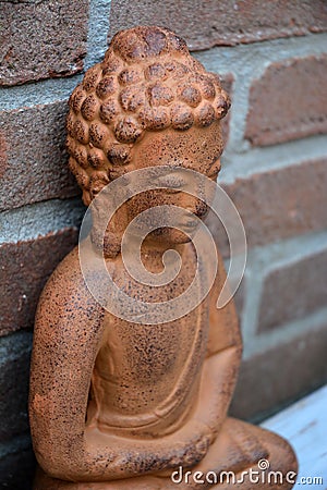 Brown Buddha with a stone bricks wall background Stock Photo