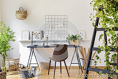 Brown chair at desk in white boho home office interior with plan Stock Photo