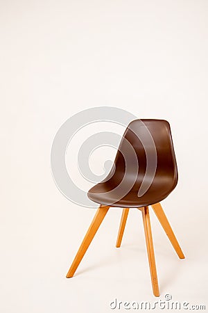 a brown chair with wooden legs stands on a white background. Stock Photo