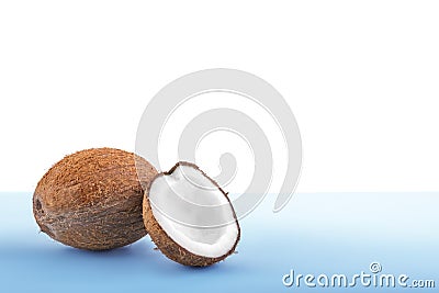 Brown coconut on a bright light blue background. Fresh coconut cut in half. Delicious tropical nuts full of nutrients. Stock Photo