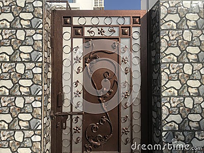 Brown color galvanised enamel painted prefabricated single leaf wicked gate for an villa backside and flower designed in the gate Stock Photo