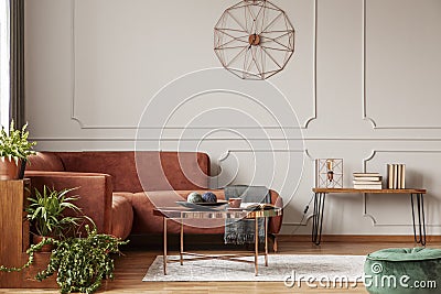 Brown comfortable corner sofa in elegant living room interior with grey wall with molding and fancy clock Stock Photo