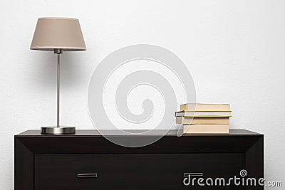 Brown commode with lamp and books in minimalism interior Stock Photo