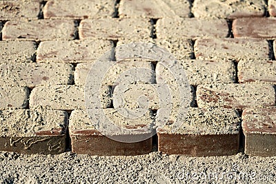 Brown concrete permeable flooring assembled on a substrate of sand. Abstract photo of bricks in the sunlight Stock Photo