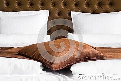 Brown cushion on a stylish double bed Stock Photo