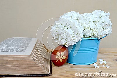 Brown Easter egg, old book and spring flowers Stock Photo