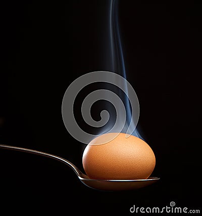 Brown egg wrapped in smoke in spoon Stock Photo