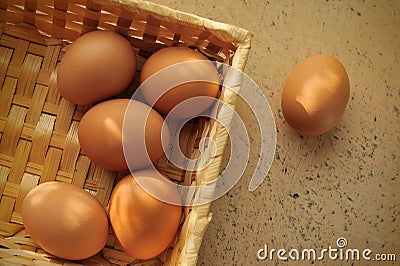 Brown eggs in a basket on textured surface Stock Photo