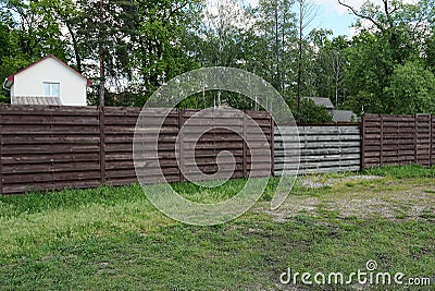 Brown fence wall and gray gate made of boards Stock Photo