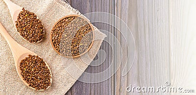 Brown flax seeds or flax seed in a small bowl on sacking Stock Photo