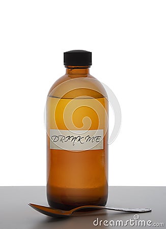 Brown glass medicine bottle with spoon and label saying `Drink me`. Magic potion, panacea, pharceutical concept Stock Photo