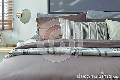 Brown and gray color scheme bedding with reading lamp Stock Photo