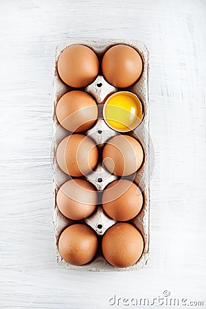 Brown hen`s eggs one egg yolk visible decorated in a box Stock Photo